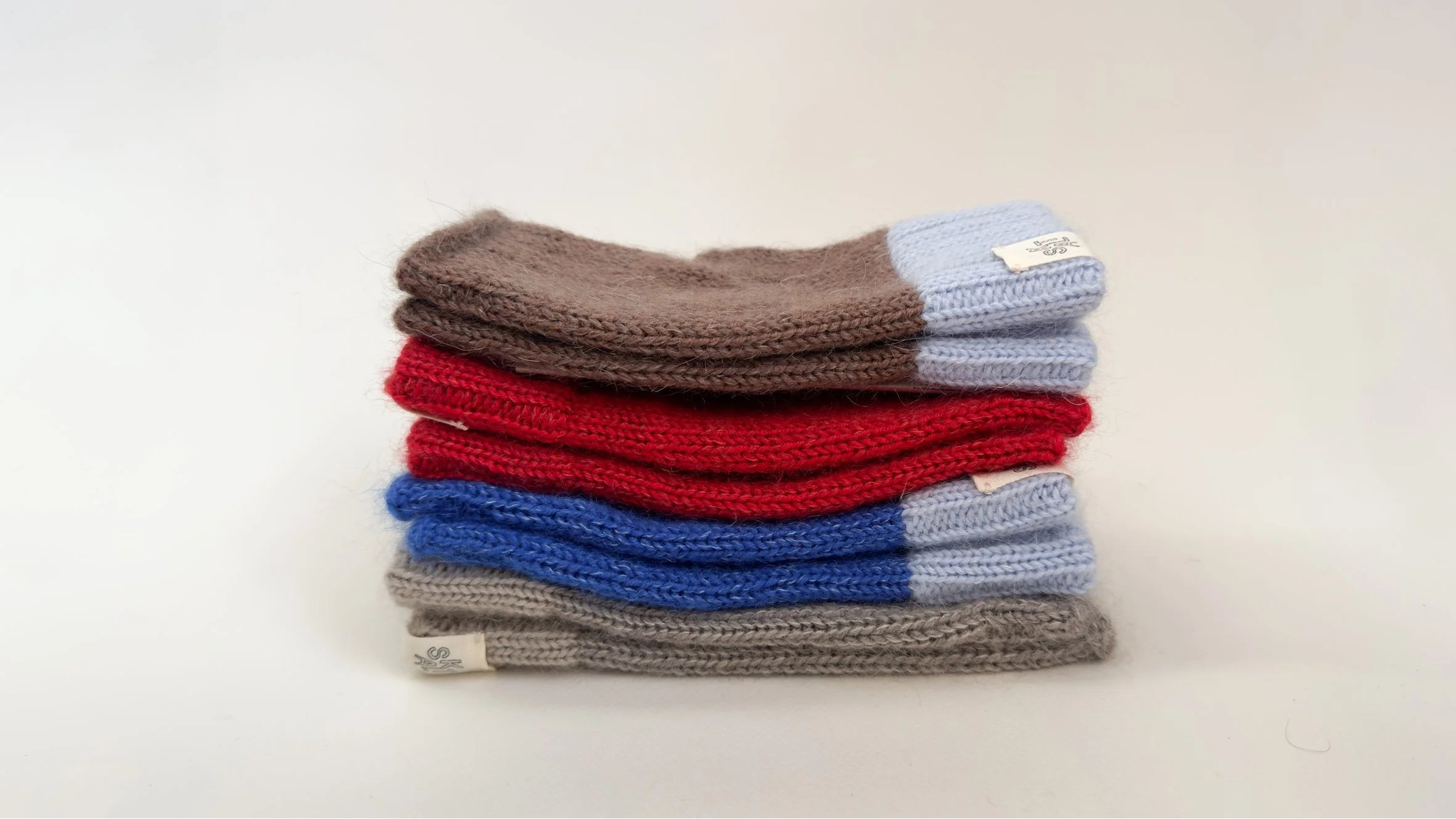 Stack of colourful gloves on a white background